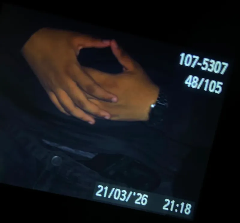 Visor da câmera mostrando duas mãos entrelaçadas, com data e hora